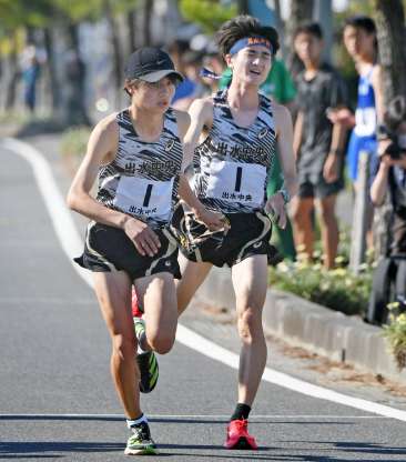 第６中継所、出水中央・坂田（右）から石丸にたすきが渡る＝指宿市（桑元伸二撮影）