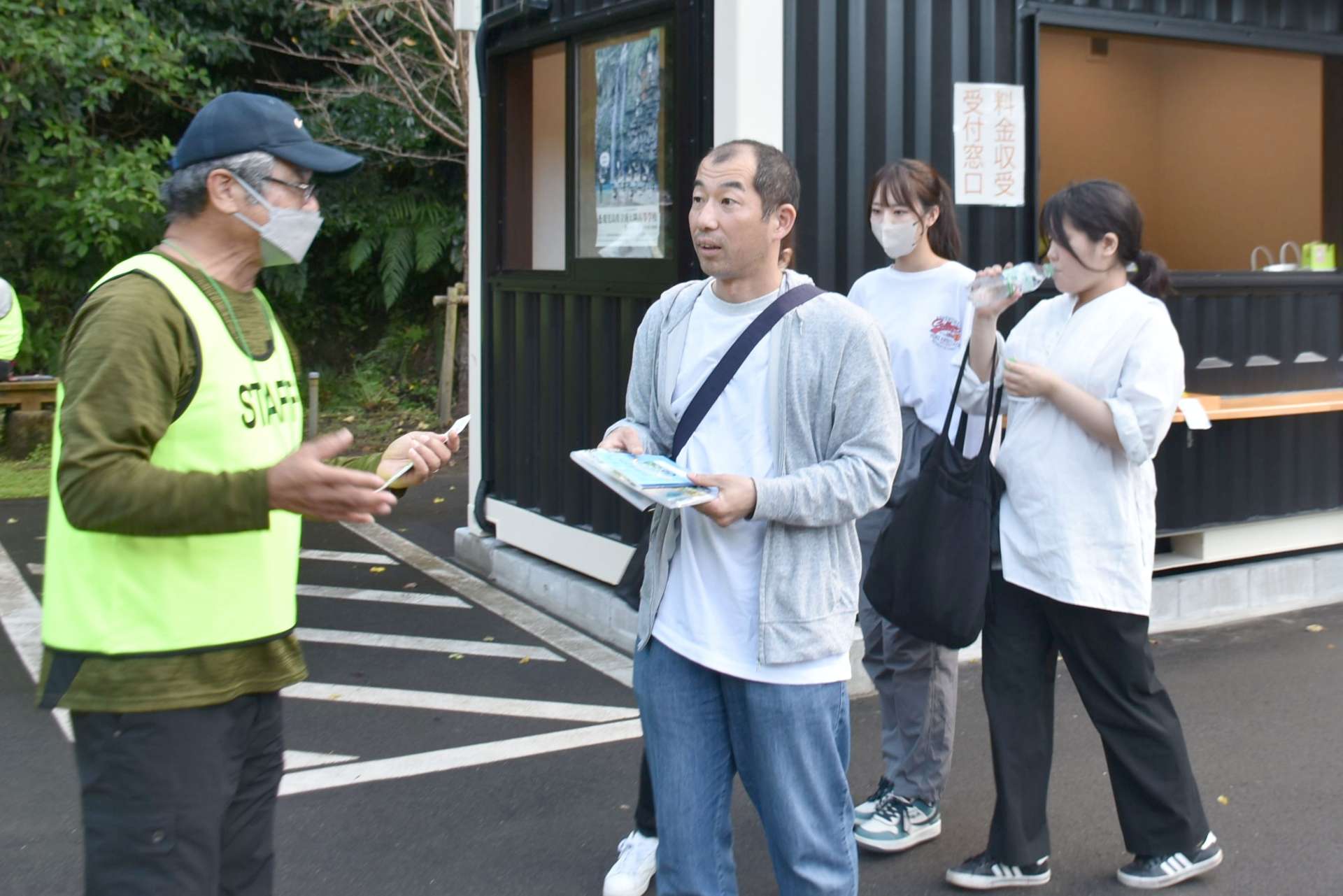雄川の滝有料化の実証実験で、観光客の対応をするスタッフ＝南大隅町根占川北