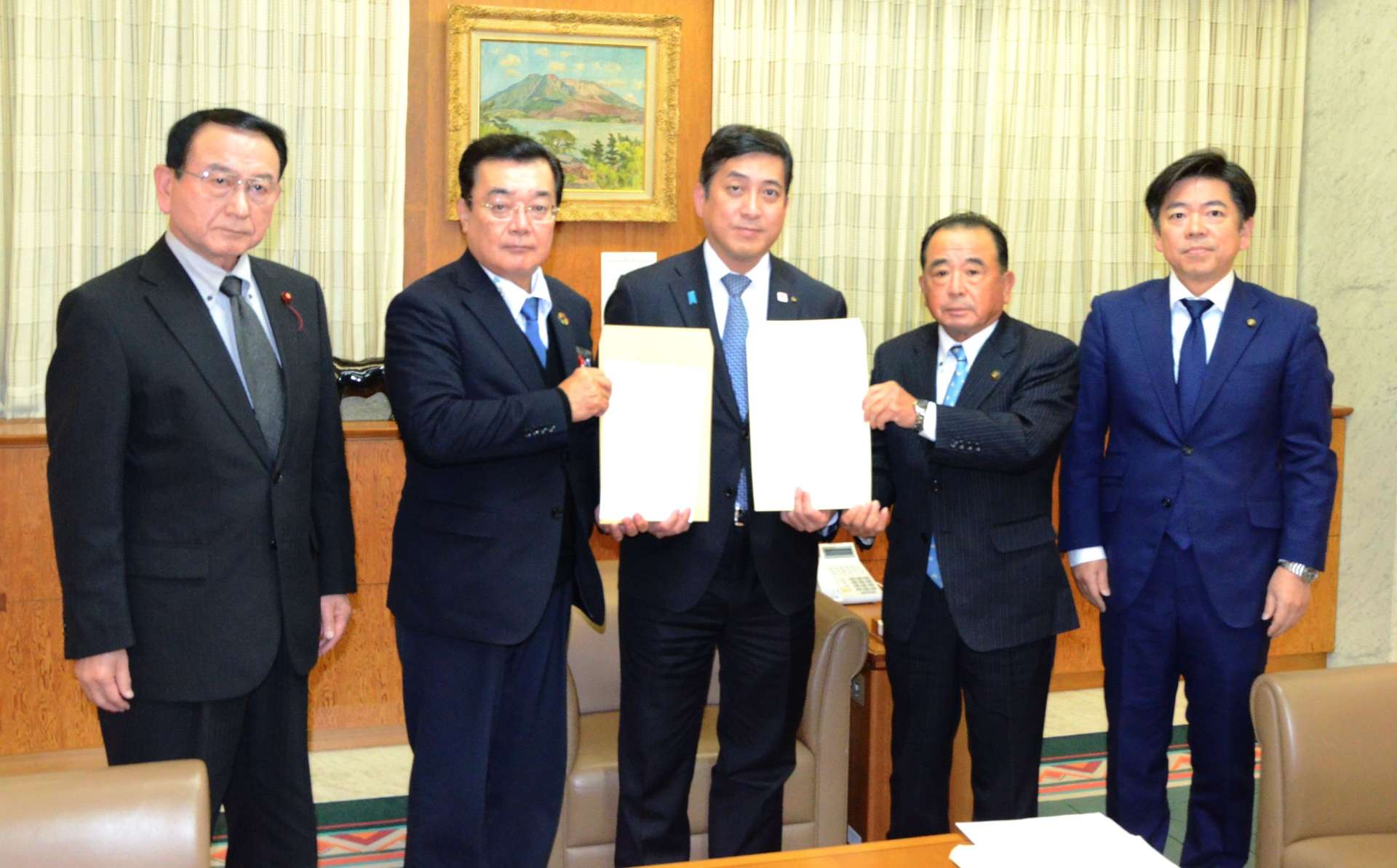 肥薩おれんじ鉄道の財政支援継続決定を塩田康一知事（中央）に伝えた県市町村振興協会の本坊輝雄理事長（右から２人目）ら＝２５日、県庁