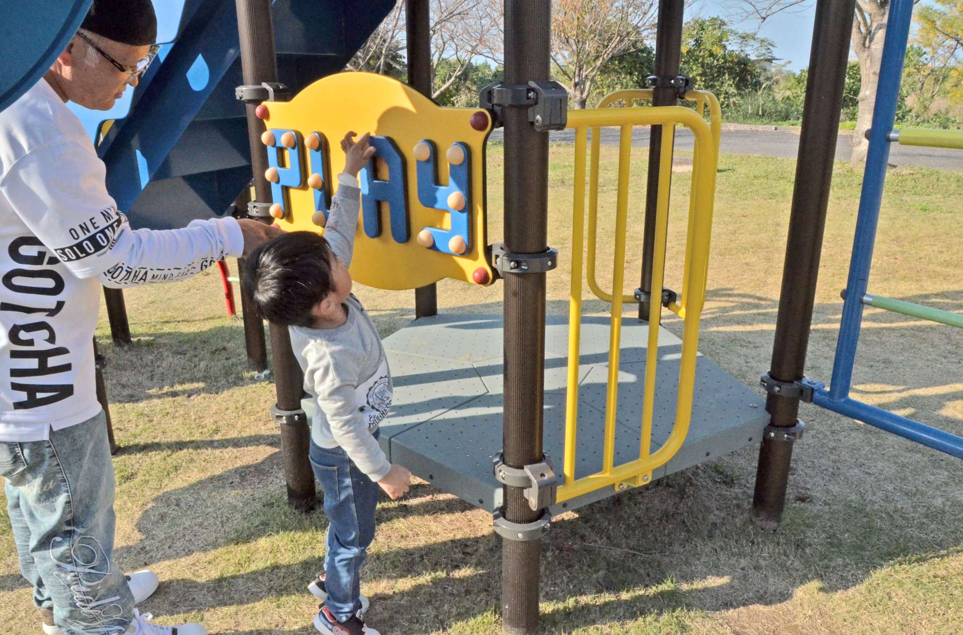 点字になっている「ＰＬＡＹ」の文字を触って確かめる親子＝出水市のツル博物館クレインパークいずみ