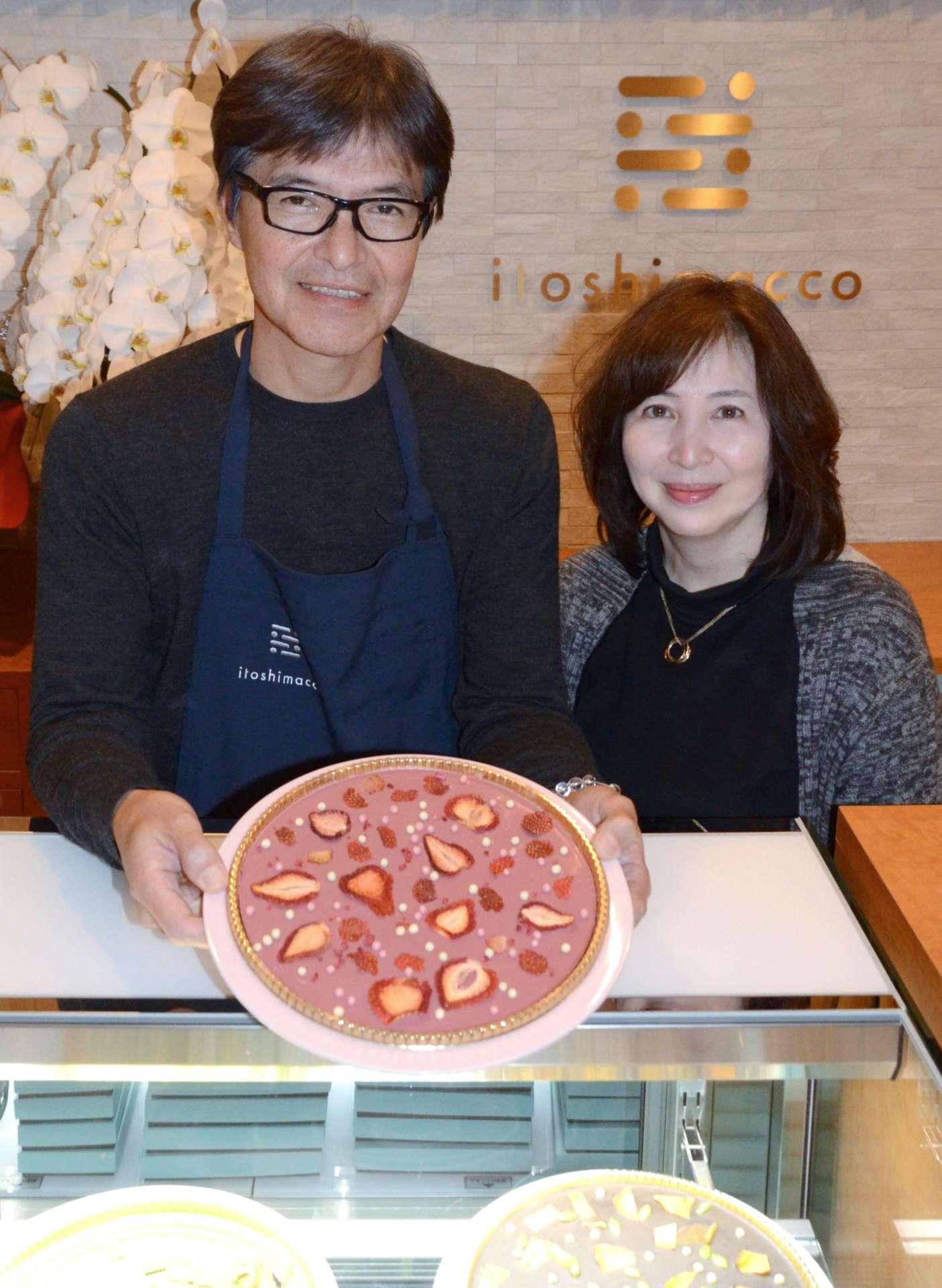 糸島産フルーツを使ったチョコレートを手にする田之上慶三郎さんと真喜子さん＝福岡県糸島市