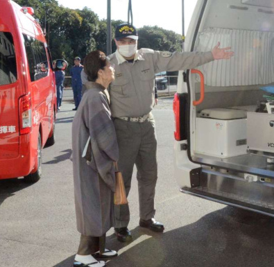 寄付金で購入された救急車の装備の説明を聞く秀島美代子さん（左）＝鹿児島市の南消防署