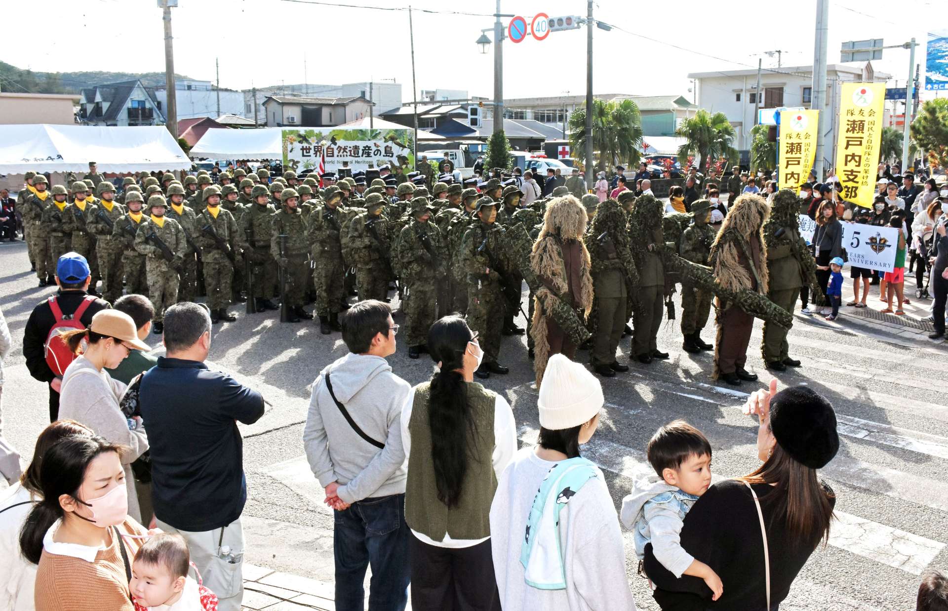 市街地のパレードで集まった陸海空の自衛隊員＝１４日、瀬戸内町古仁屋