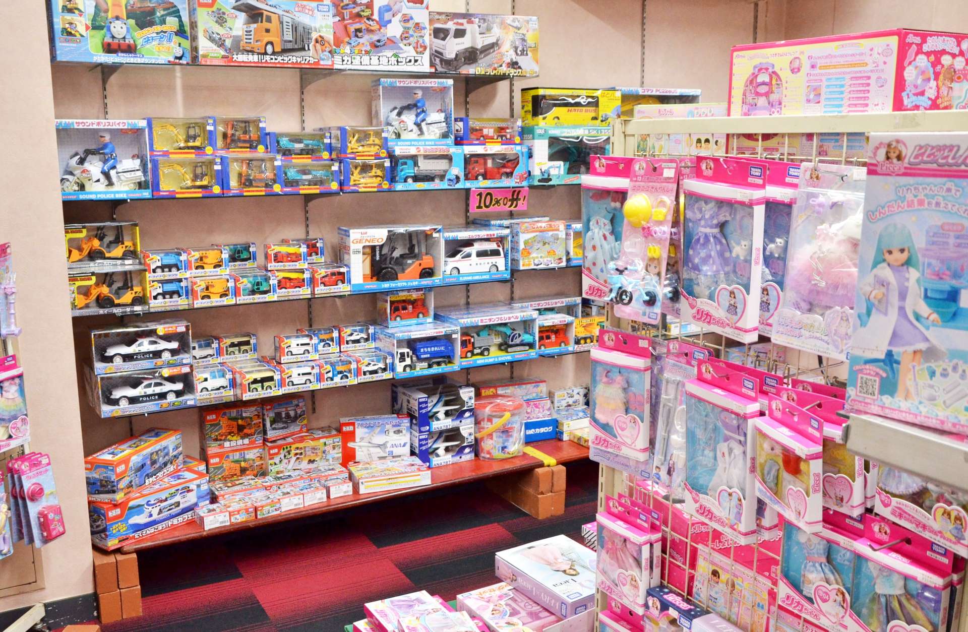 〈関連〉人形の近くに車のおもちゃが並ぶおもちゃ屋。売り場を性別で分けていない＝鹿児島市の丸新玩具中町本店
