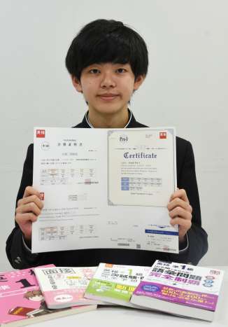 〈関連〉「単語や文法などの基礎知識習得に使った」という参考書を並べ、喜ぶ石堂和佑紀さん＝中種子町の種子島中央高校