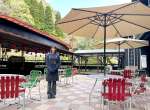 温泉カフェ「湯らり～な」テラス席に立つ浜弓場美来店長＝霧島市隼人町嘉例川