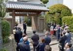 復元された御門の修繕内容について説明を受ける式典出席者＝３月３０日、都城市早鈴町
