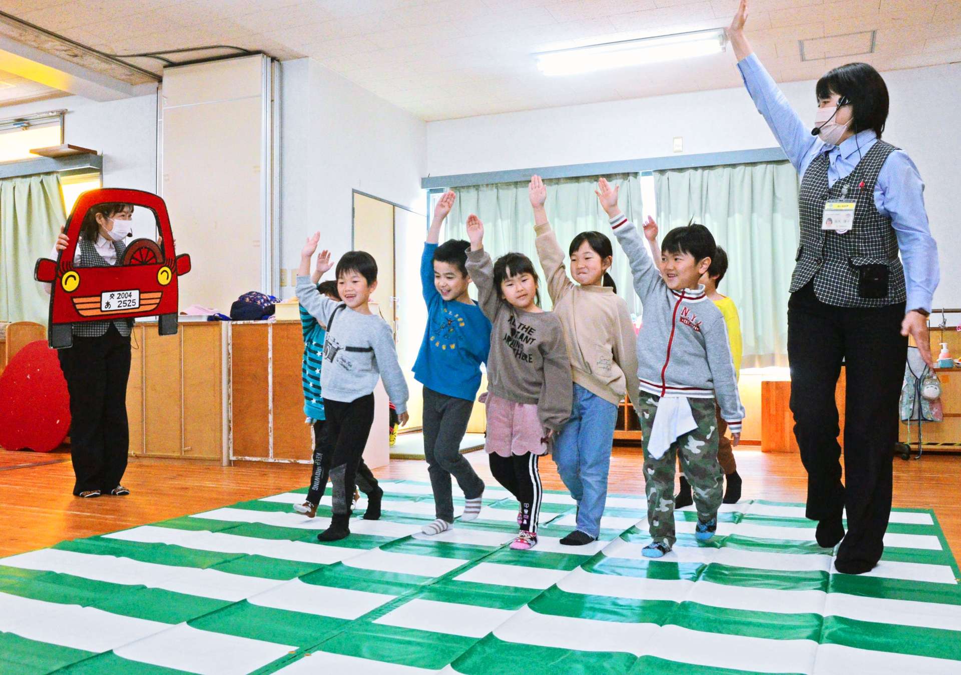 手を上げた横断歩道の渡り方を練習する園児ら＝鹿児島市のたけおか保育園
