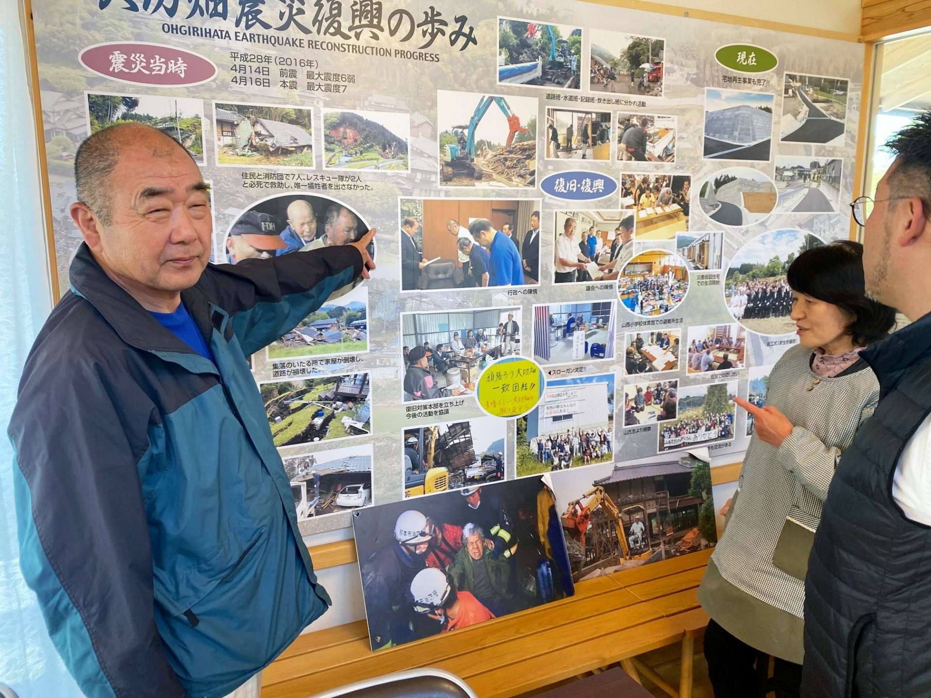 再建された集会所「みんなの家」で復興までの道のりを説明する坂田哲也さん（左）ら＝熊本県西原村の大切畑地区