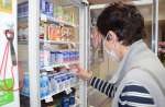 瓶入り牛乳の販売終了を受け、空いたスペースに紙パック製品を並べる従業員＝鹿児島市の錦湯