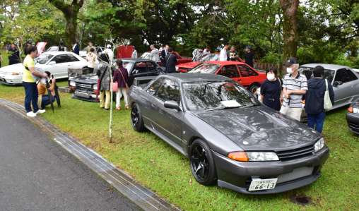往年の名車に見入る来場者＝２１日、指宿市のかいもん山麓ふれあい公園