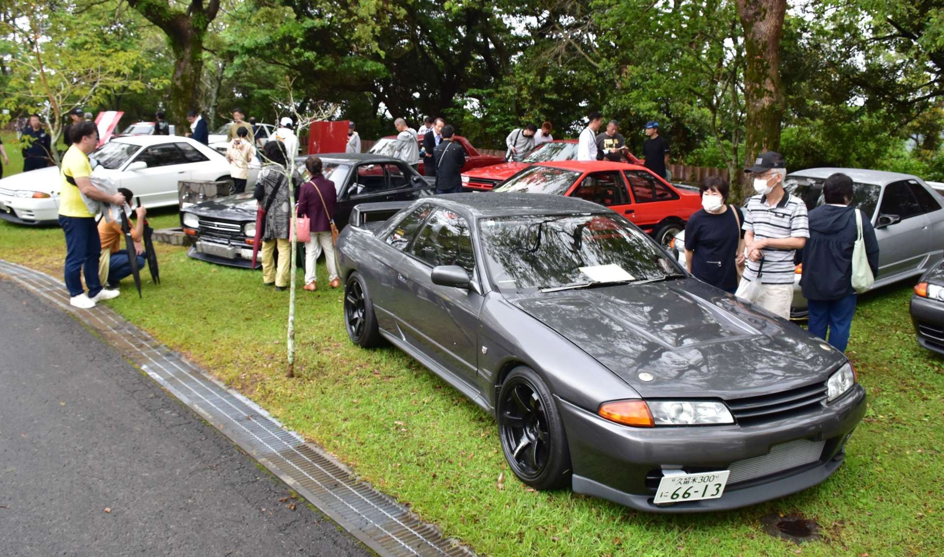 往年の名車に見入る来場者＝２１日、指宿市のかいもん山麓ふれあい公園