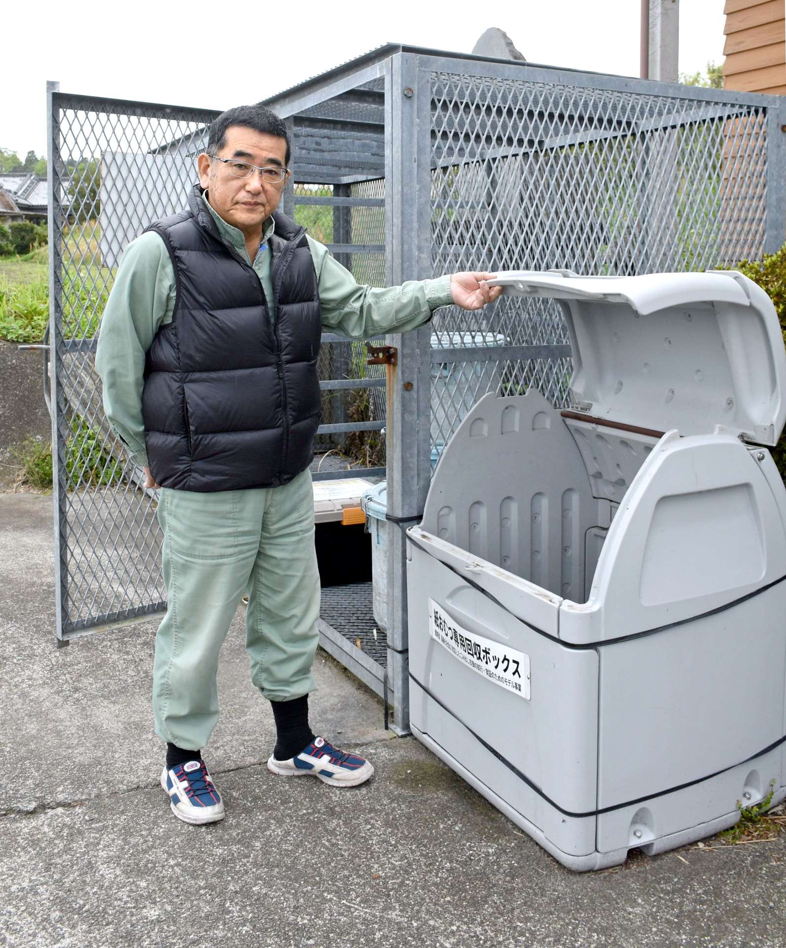 大崎町の紙おむつ専用回収ボックスを案内する山野利高さん＝同町井俣
