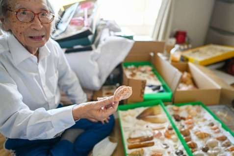 〈関連〉居室で貝殻を手にする溝口貞雄さん（ついまでおつとめのあるホーム提供）