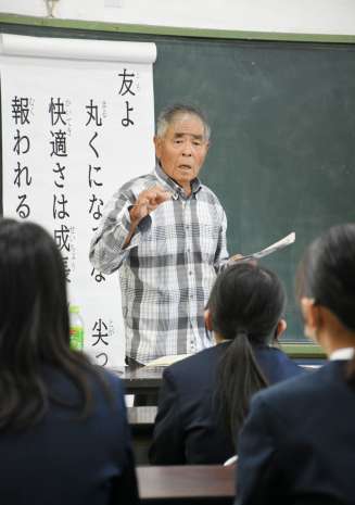 〈別カット〉自身の体験を交え、戦時の暮らしを紹介する政田一雄さん＝中種子町の増田小学校