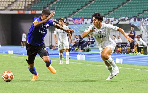 前半、サイドから攻め込む鹿児島ＵのＤＦ小島（右）＝レゾナックドーム大分
