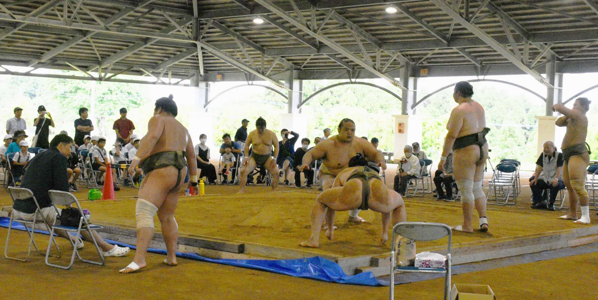 大勢の見学客の前で激しい稽古を披露する放駒部屋の力士たち＝１８日、西之表市の「あっぽ〜らんど」