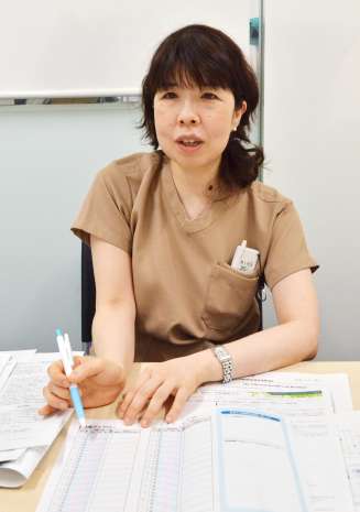 頭痛記録のつけ方を説明する花田朋子医師＝鹿児島市の鹿児島大学病院