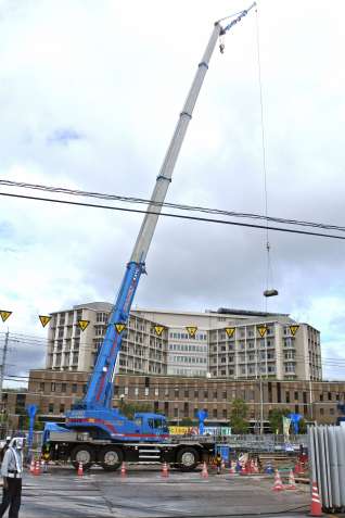 鹿児島市立病院（奥）の道路向かいに建設される１４階建てマンションの工事現場＝鹿児島市上荒田町