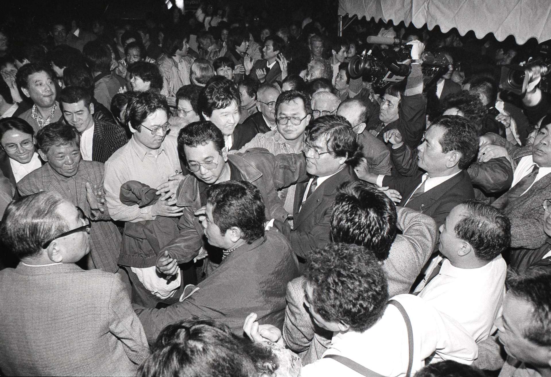 １９９０年２月１８日、３度目の挑戦で衆院選初当選を果たし、支持者に囲まれる徳田虎雄さん（中央）＝名瀬市（当時）