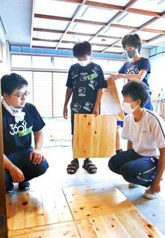 町長室改修のため、床張りをする中学生ら＝錦江町役場