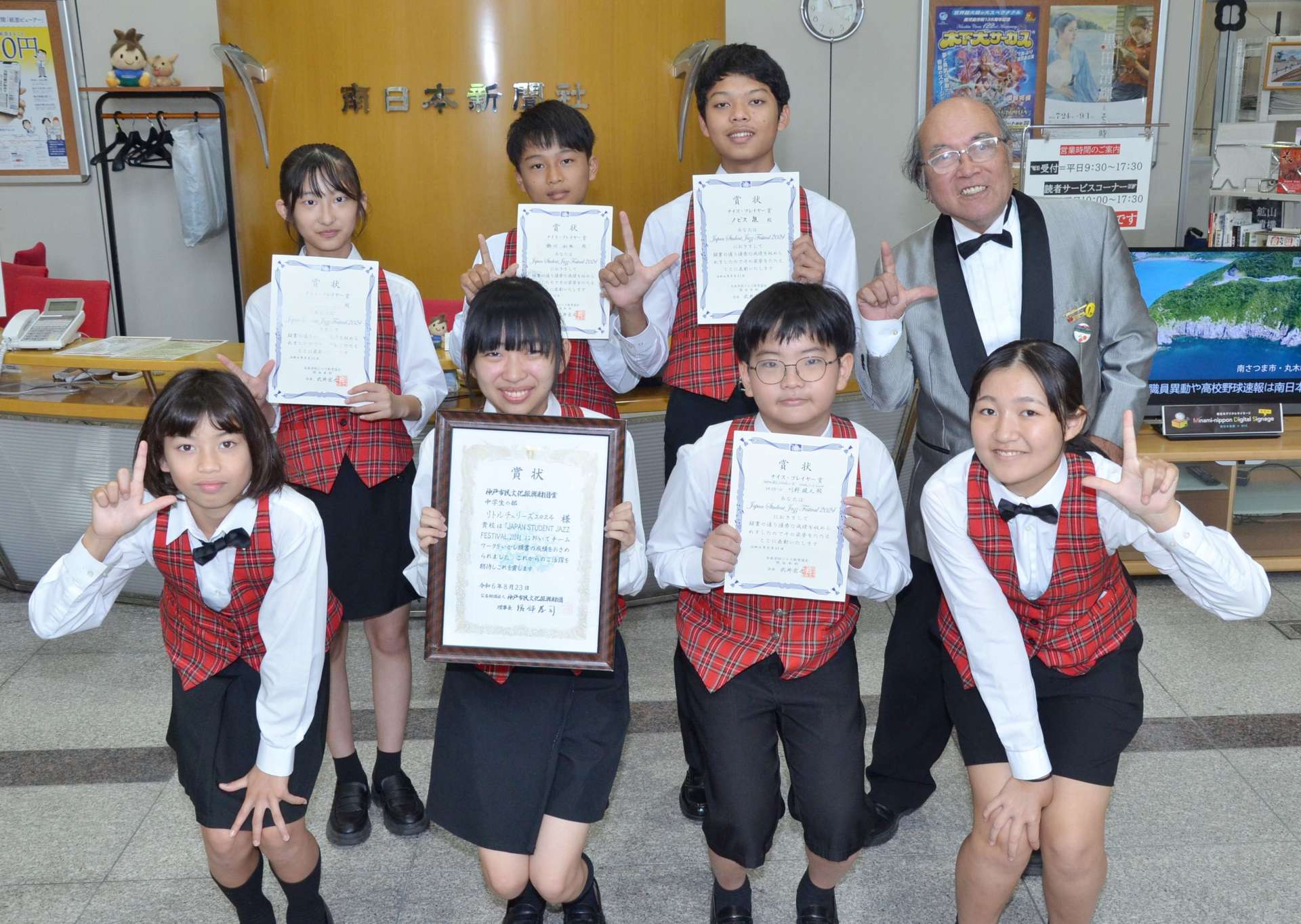 入賞を喜ぶリトルチェリーズの団員ら＝３０日、鹿児島市の南日本新聞社