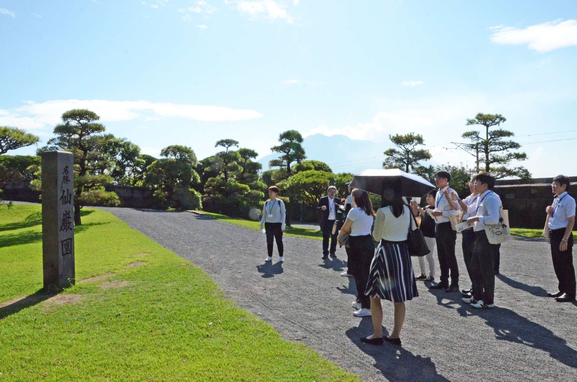 仙巌園についての説明を聞く大阪と名古屋の旅行業者ら＝６日、鹿児島市の仙巌園