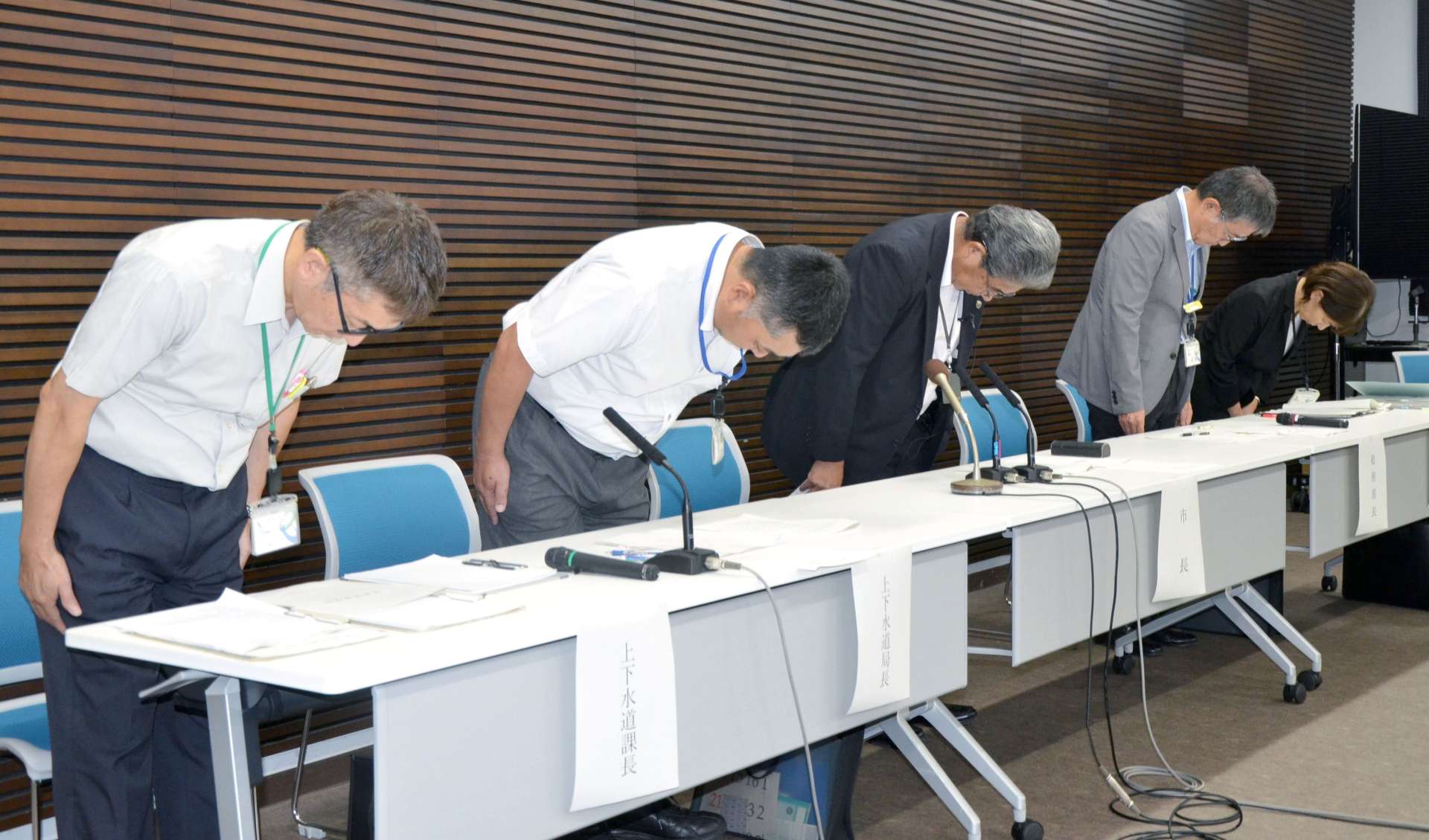 会見前に事件について陳謝する宮原義久市長（中央）ら小林市関係者＝６日、同市役所