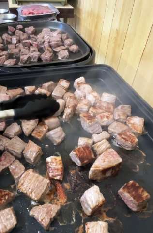 地元産牛肉のサイコロステーキ＝西之表市西之表の美浜町自治公民館