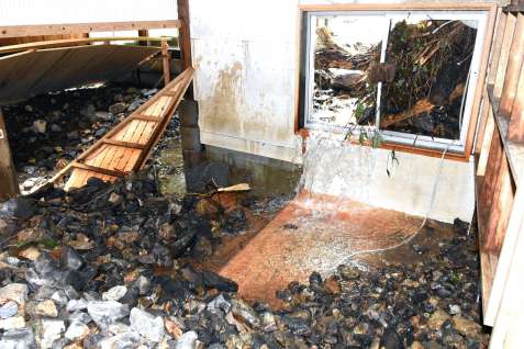 石や水が流れ込むなど被災した湯川内温泉かじか荘。右手前は脱衣所、左奥は浴室＝出水市武本