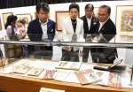 海老原喜之助の手掛けた雑誌の表紙を紹介する海老原あかねさん（中央）＝１０日、志布志市文化会館
