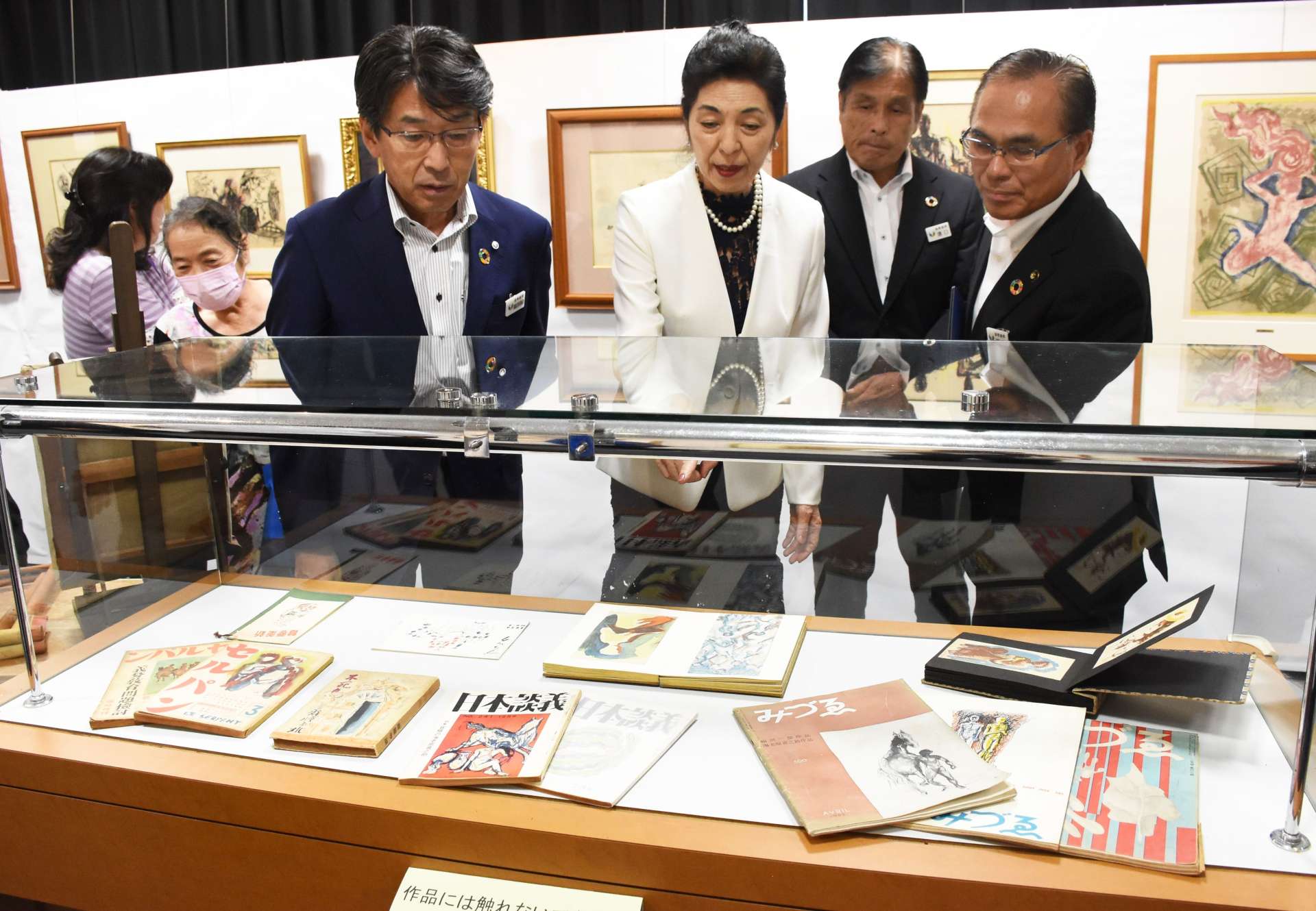 海老原喜之助の手掛けた雑誌の表紙を紹介する海老原あかねさん（中央）＝１０日、志布志市文化会館
