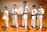 世界硬式空手道選手権大会で３位になった稲付蓮斗さん（中央）と日本代表として出場した真輝塾メンバー＝志布志市の志布志運動公園武道館