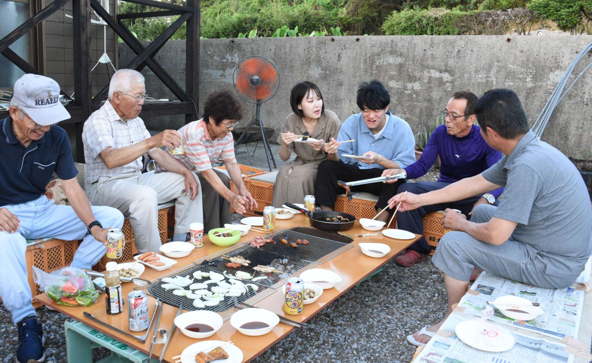 加納直樹さん（右から３人目）、李彩さん（同４人目）夫妻を囲む里親の小脇静己さん（同２人目）＝南種子町西之