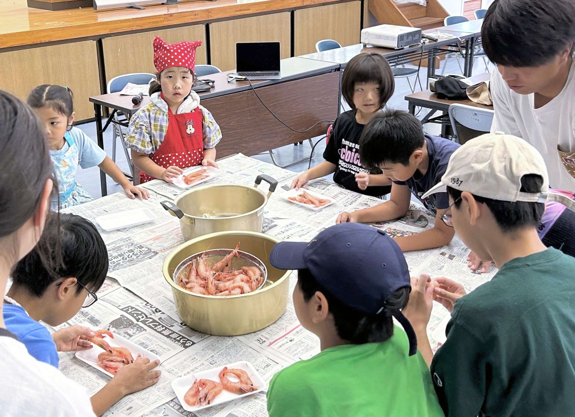 タカエビの殻むきを体験する子どもたち＝南さつま市笠沙