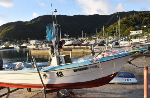 台風１３号の接近に備え、船を陸揚げする関係者＝１２日、奄美市名瀬の大熊港