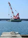 海中にケーソンを据え付けるクレーン＝薩摩川内市の川内港唐浜地区