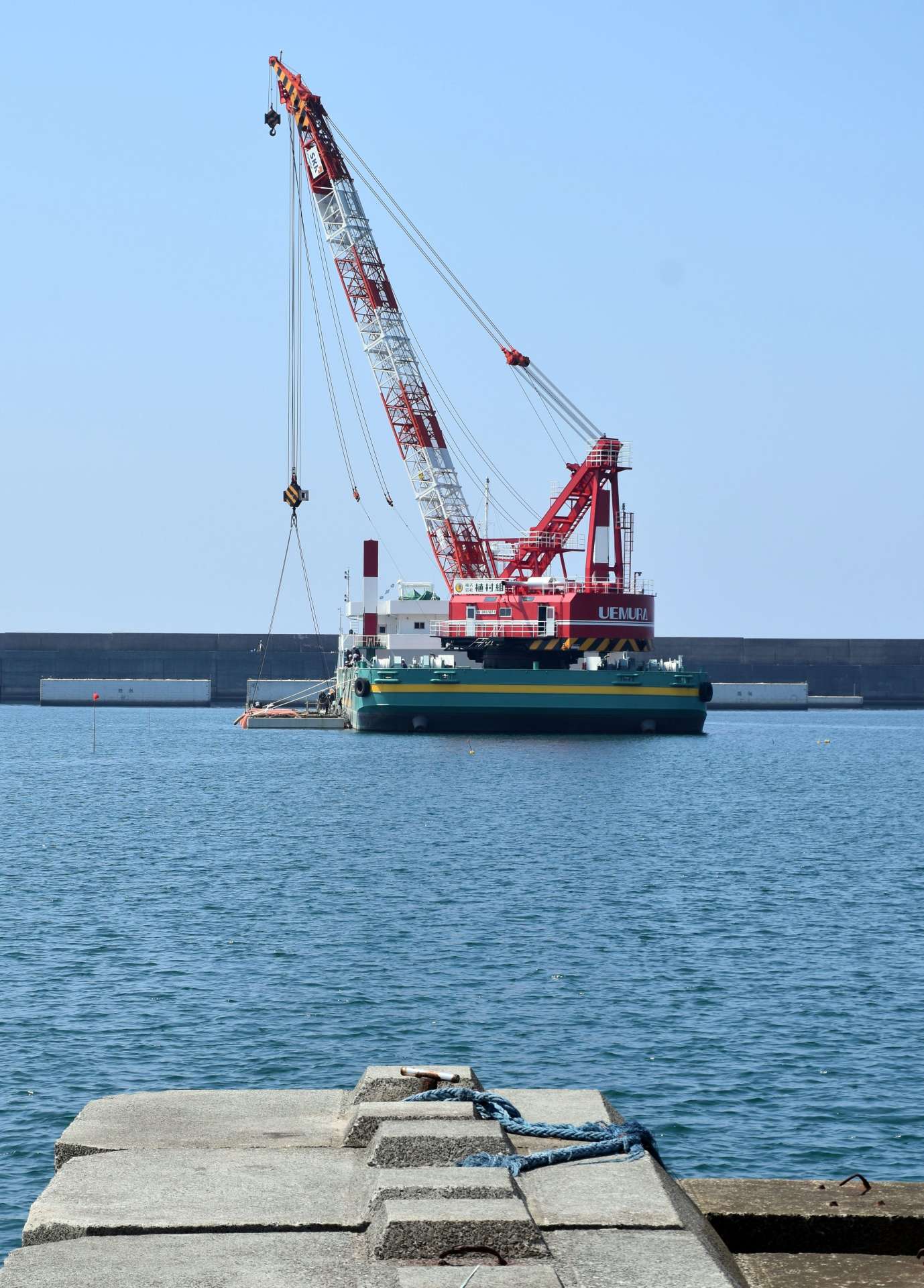 海中にケーソンを据え付けるクレーン＝薩摩川内市の川内港唐浜地区