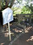 竜宮伝説ゆかりの地「玉の井」と近くに立つ現在の立て札＝指宿市開聞
