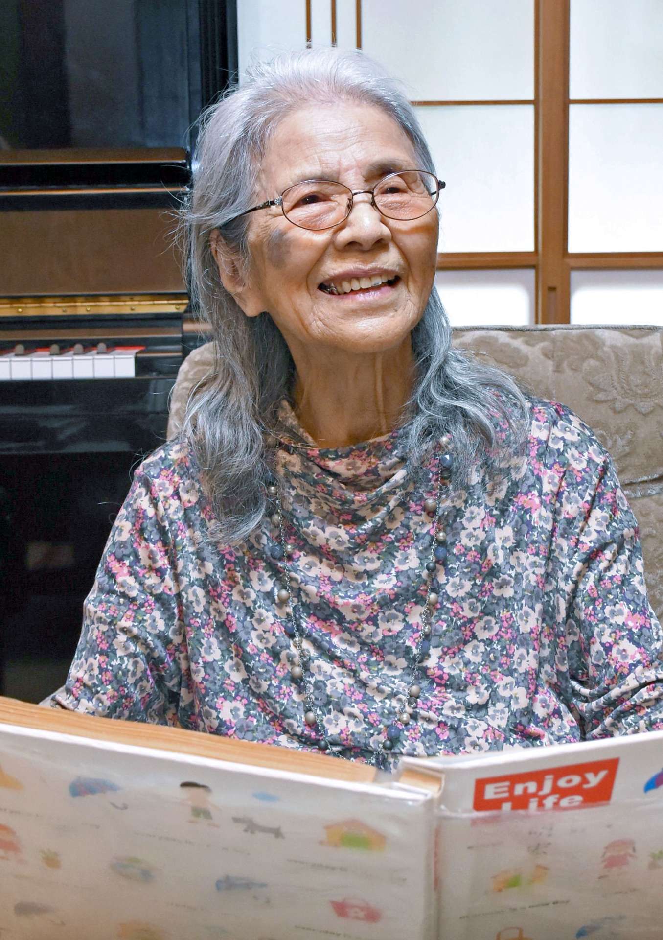 アルバムを見ながら思い出を語る東和子さん＝霧島市国分松木町