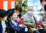 塩田康一知事（右）から声をかけられる高下マサヲさん＝１５日、さつま町紫尾