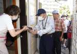 巻きずしを受け取る高齢者ら＝１６日、鹿児島市真砂本町の寿司孝