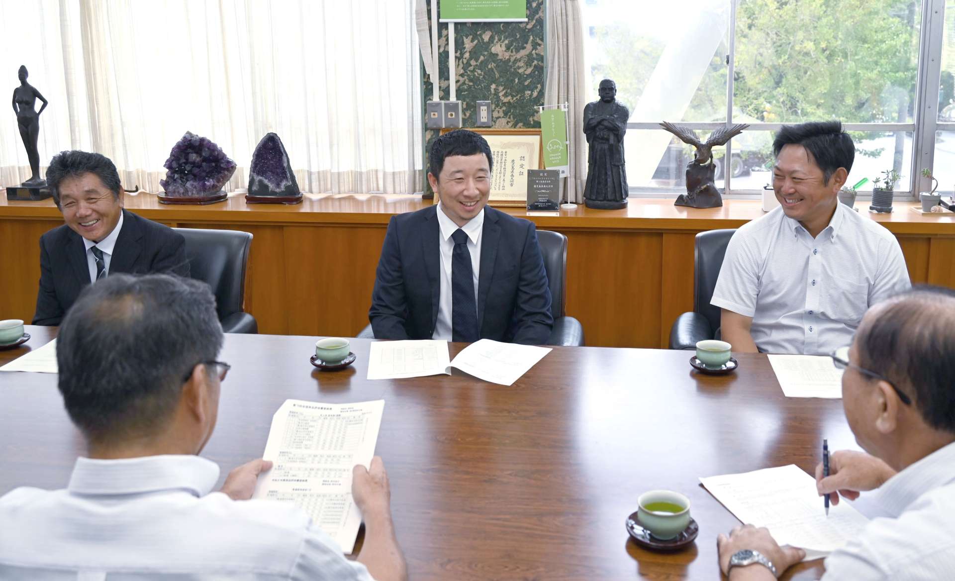 茶品評会での受賞を報告する（右から）枦川克可さん、前原翔太さん、折尾義昭さん＝南九州市役所
