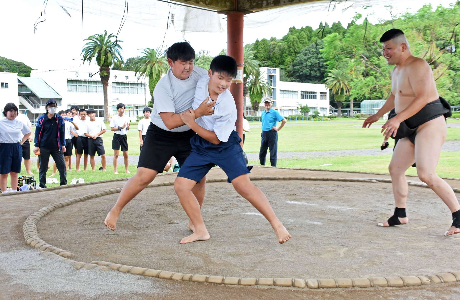 取り組みで熱戦を繰り広げる伊崎田中の生徒＝志布志市有明の伊崎田小相撲場