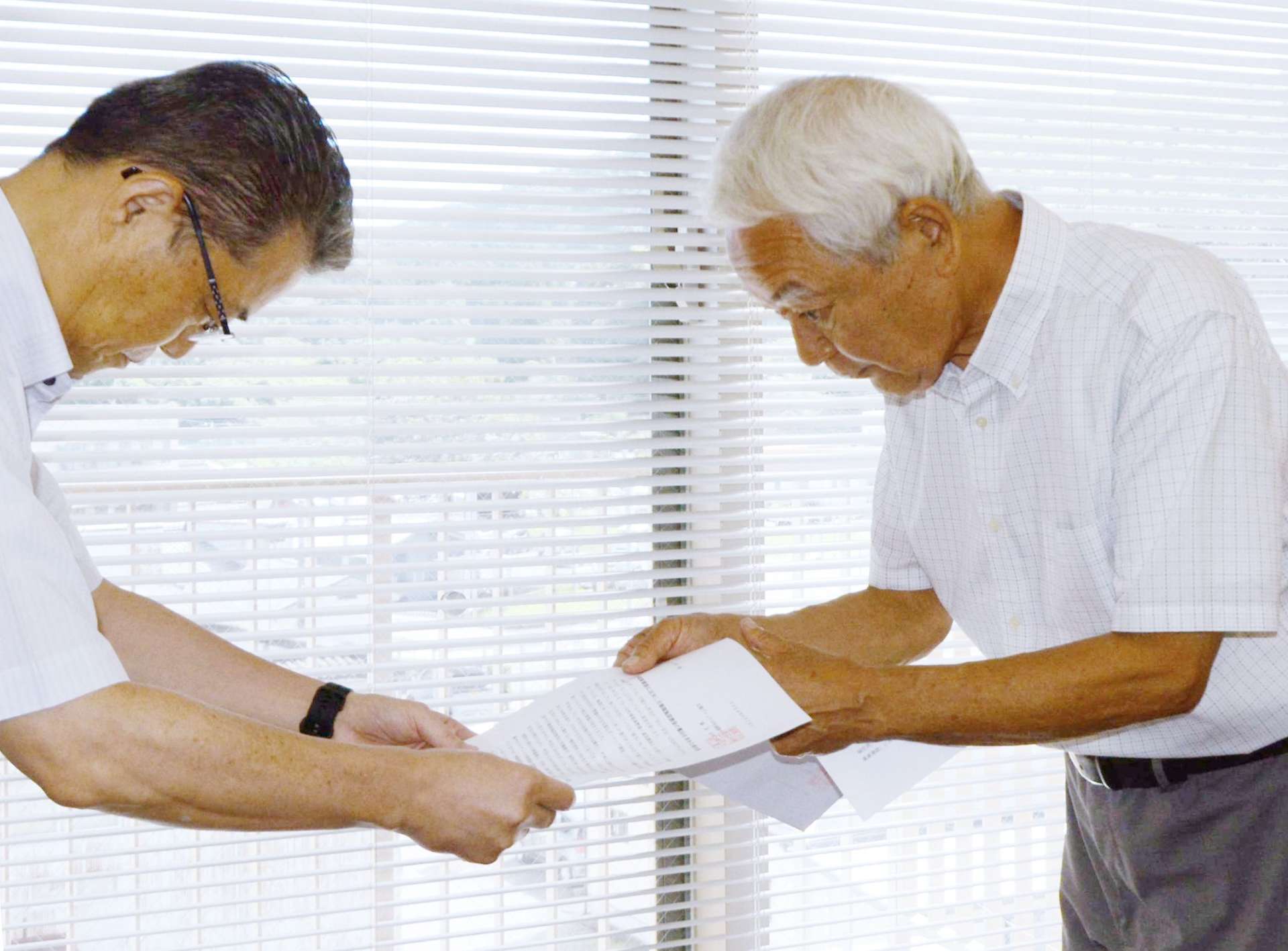 要求書を手渡す北薩ブロック平和運動センターの早崎当和事務局長（右）＝１８日、さつま町役場