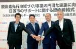 脱炭素社会の実現に向け、サポート契約を締結する関係者＝１９日、鹿児島市の鹿児島銀行本店ビル