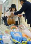 アミュプラザ鹿児島開業２０周年の花束を受け取る来館者＝１７日、鹿児島市