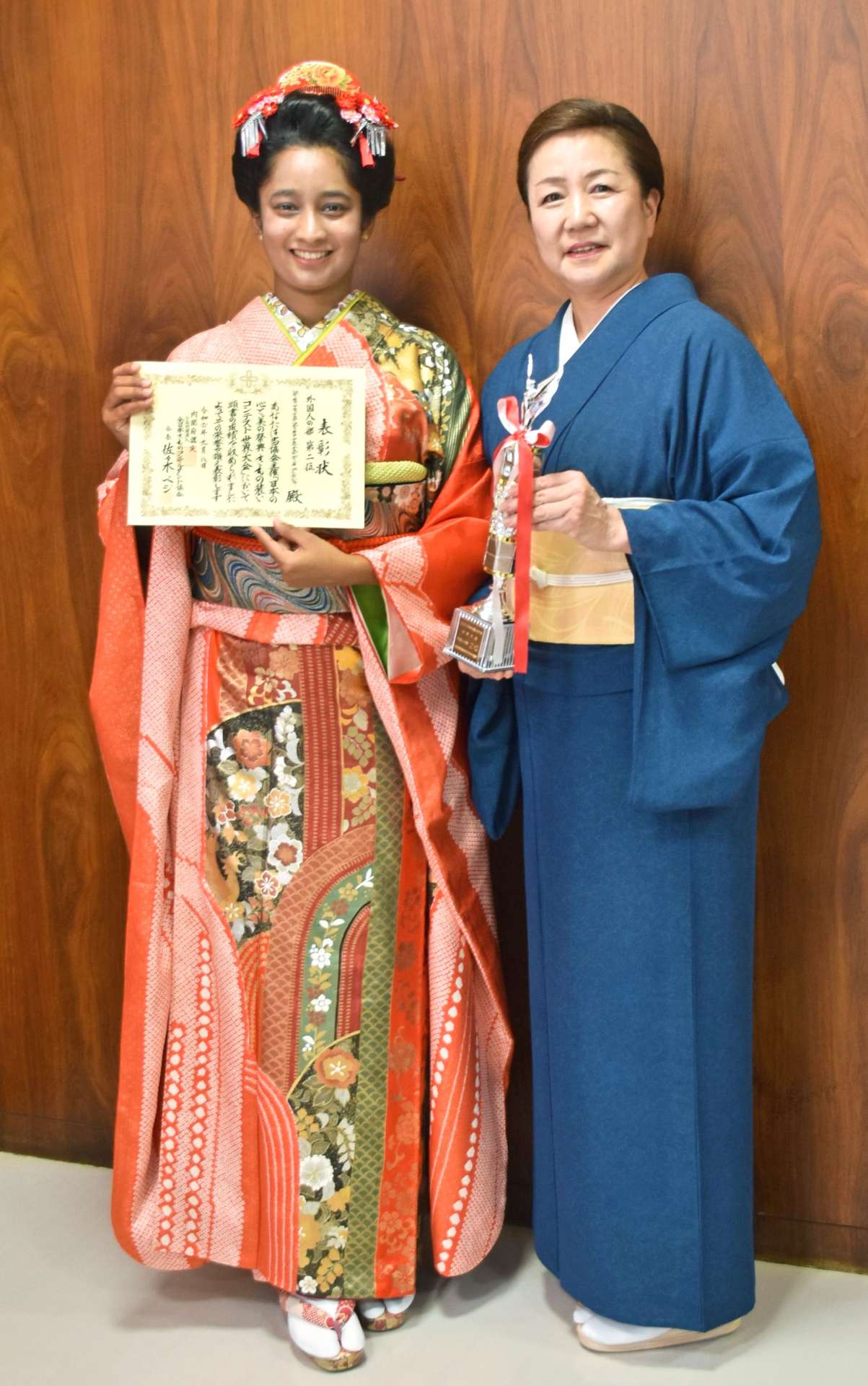 賞状を手に笑顔を見せるコディカラ・アラッチラゲ・ディルキ・プンヤジャさん（左）と、大久保尚美さん＝いちき串木野市役所