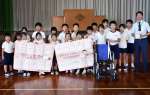 車椅子や寄せ書きなどを贈る児童ら＝湧水町の上場小学校