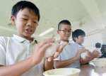 熱々の新米おにぎりを作る児童＝南さつま市の大浦小学校